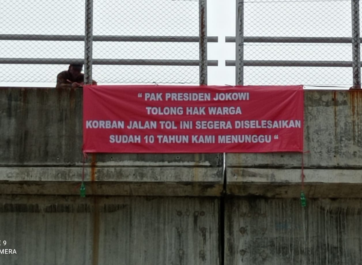 Warga Korban Jalan Tol Memasang Spanduk Bertuliskan “Pak Presiden Jokowi Tolong Hak Warga Korban Jalan Tol Ini Di Selesaikan Sudah 10 Tahun Kami Menunggu”